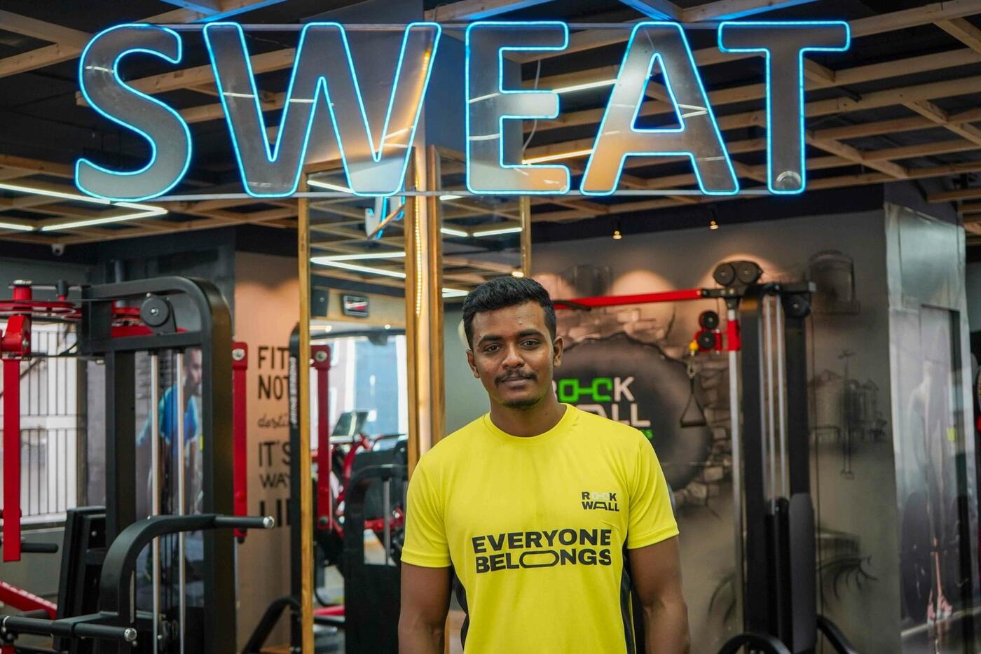 A Rockwall Fitness coach on the training floor in an Everyone Belongs tee