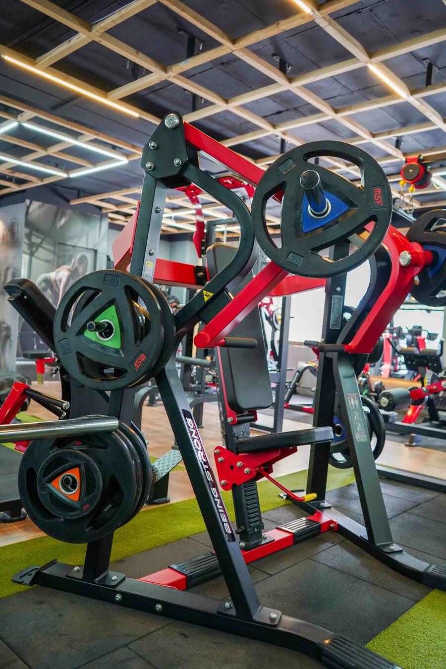 Colour-coded weight plates on a plate tree